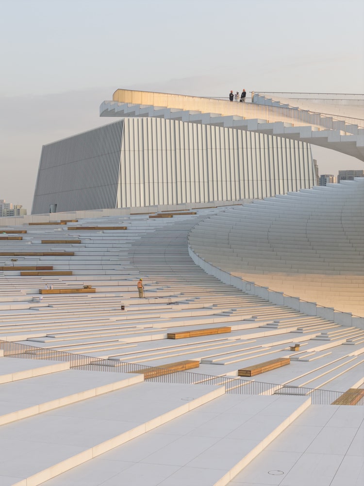 Detailed view of the white exterior staircase and integrated wooden benches on the accessible roof of the opera house.