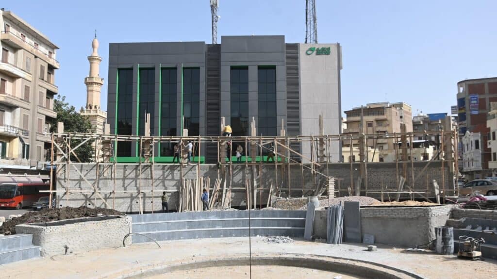 Construction workers installing the final architectural elements during the public square revitalization of Aziz Othman Square.