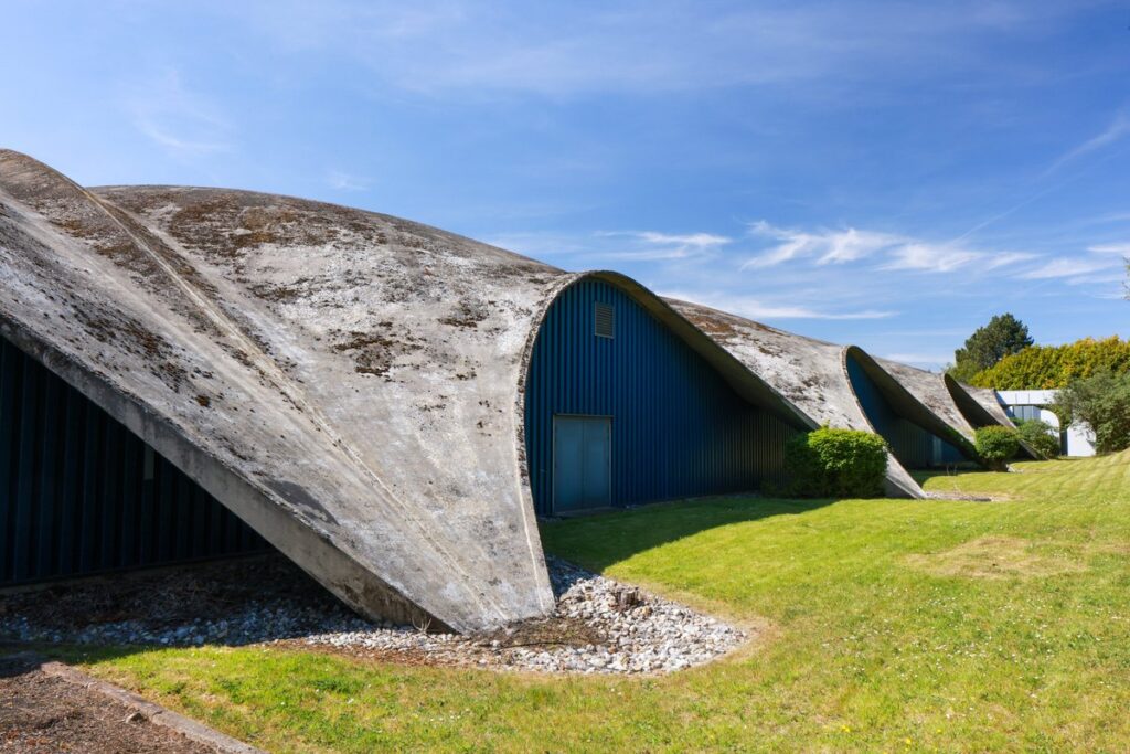 نظرة مقربة على السقف الخرساني المنحني في قرية نورويتش الرياضية، وهو تصميم أيقوني للمهندس هاينز إيسلر، يظهر ملمسه وشكله.