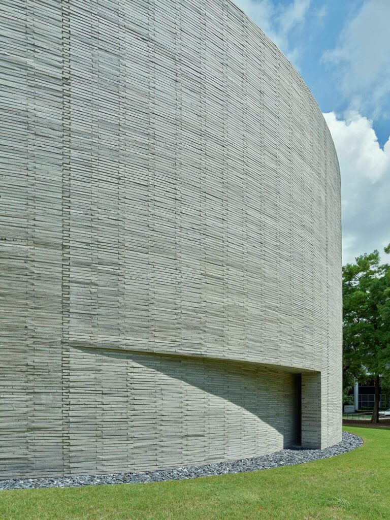 Detail of the Circular Chapel facade showing hand-made terra-cotta bricks arranged in a zipper coursing pattern.