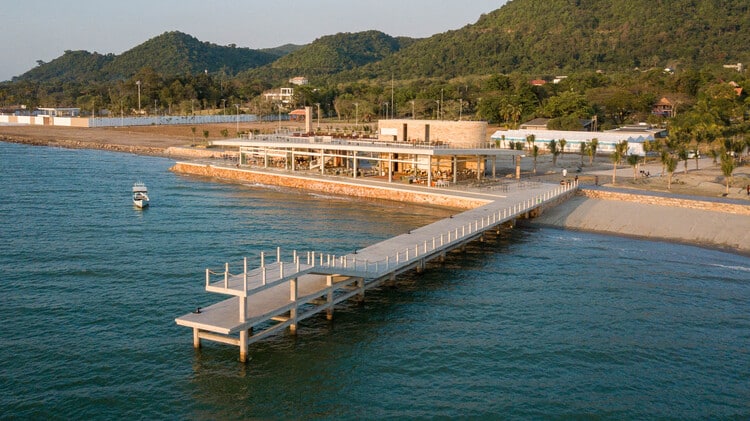 Render of The Beach Club's infinity pool and lounge area at the Kep coastal development, overlooking the ocean.