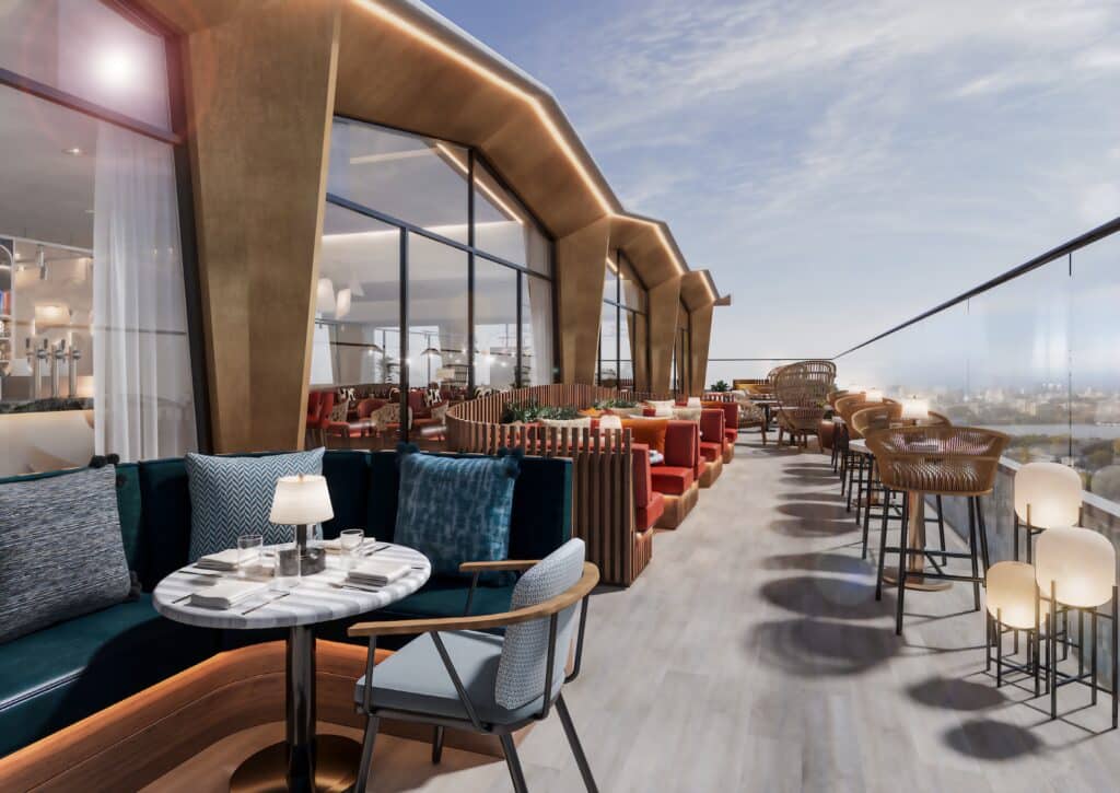 An aerial evening view showing the proposed office tower illuminated against the London skyline, integrated with the historic station below.