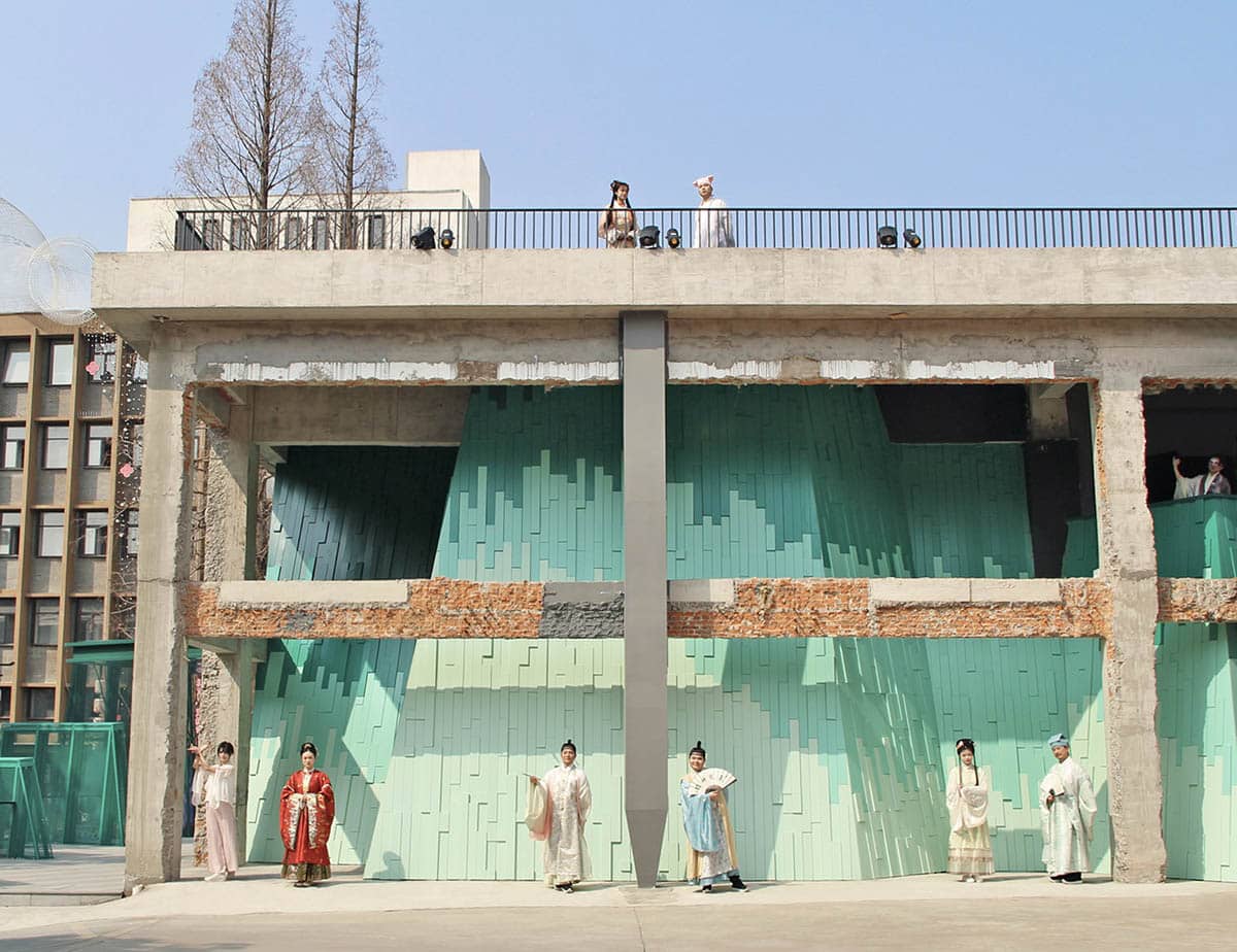 A full view of the modern Suzhou Architecture project, showing its clean white form contrasting with the surrounding traditional gray-tiled roofs