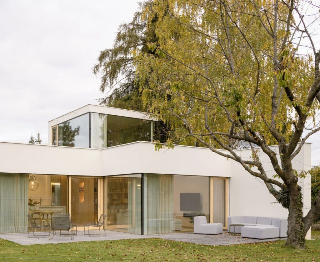 Modern outdoor terrace of Sestajovice House with floor-to-ceiling glass walls and a second-story lightweight workspace studio.