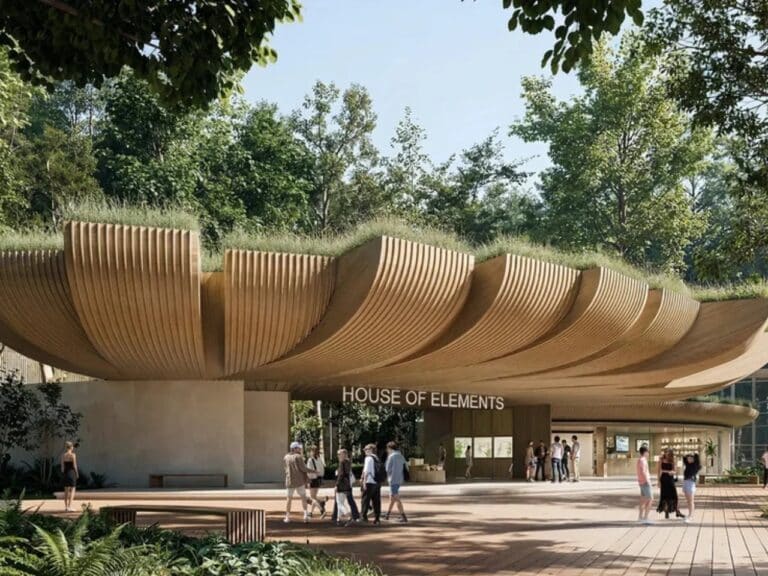 Main entrance of House of Elements at Lodz Zoo featuring a massive cantilevered wooden biophilic canopy with green roof and visitors walking underneath.