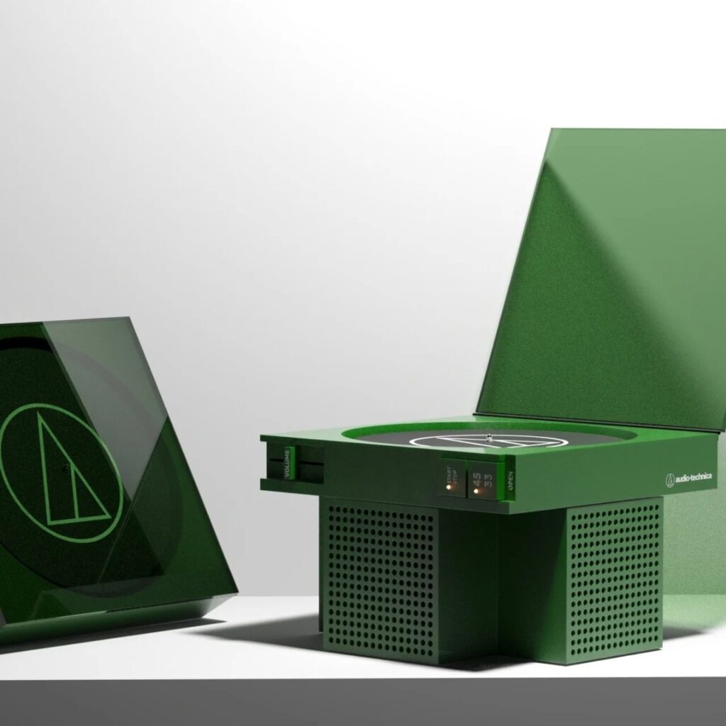 Two forest green vinyl record players, one open showing the turntable and one closed, featuring integrated speaker grills and minimalist controls.