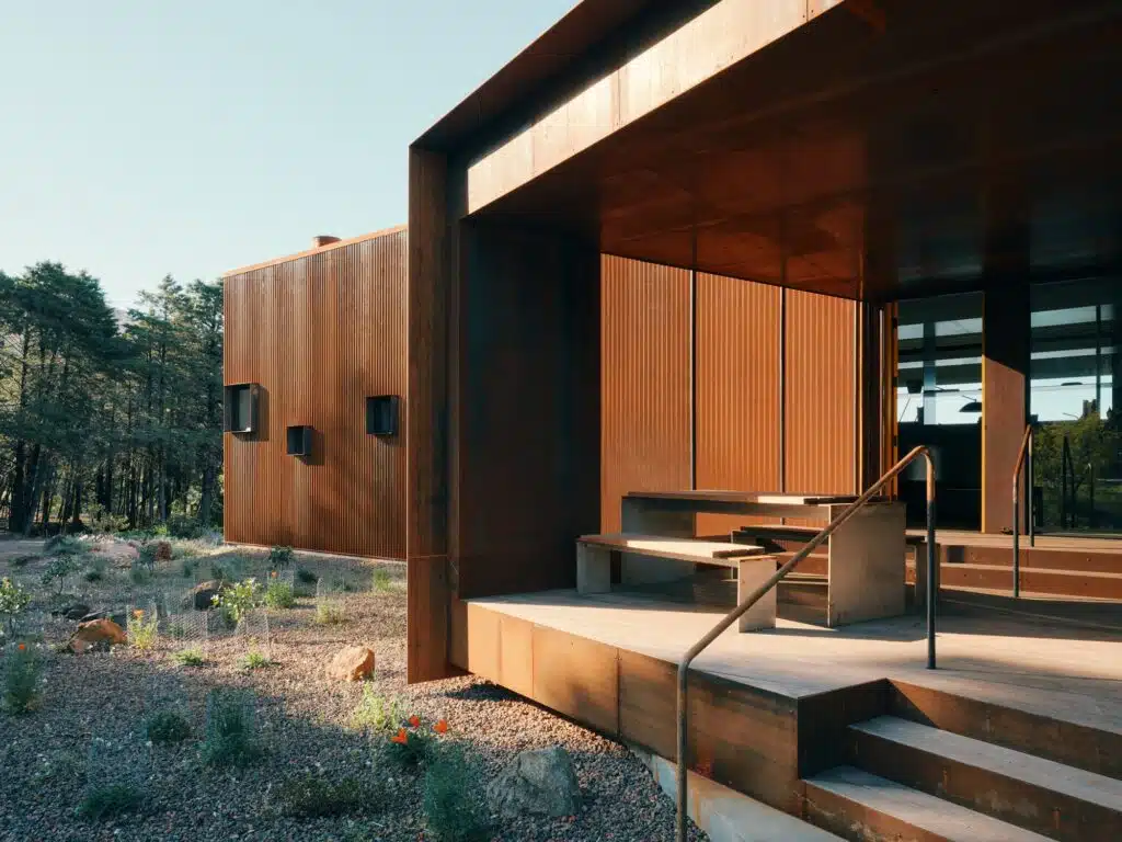 Close-up of the accessible entrance ramp and outdoor seating area made of concrete and steel.