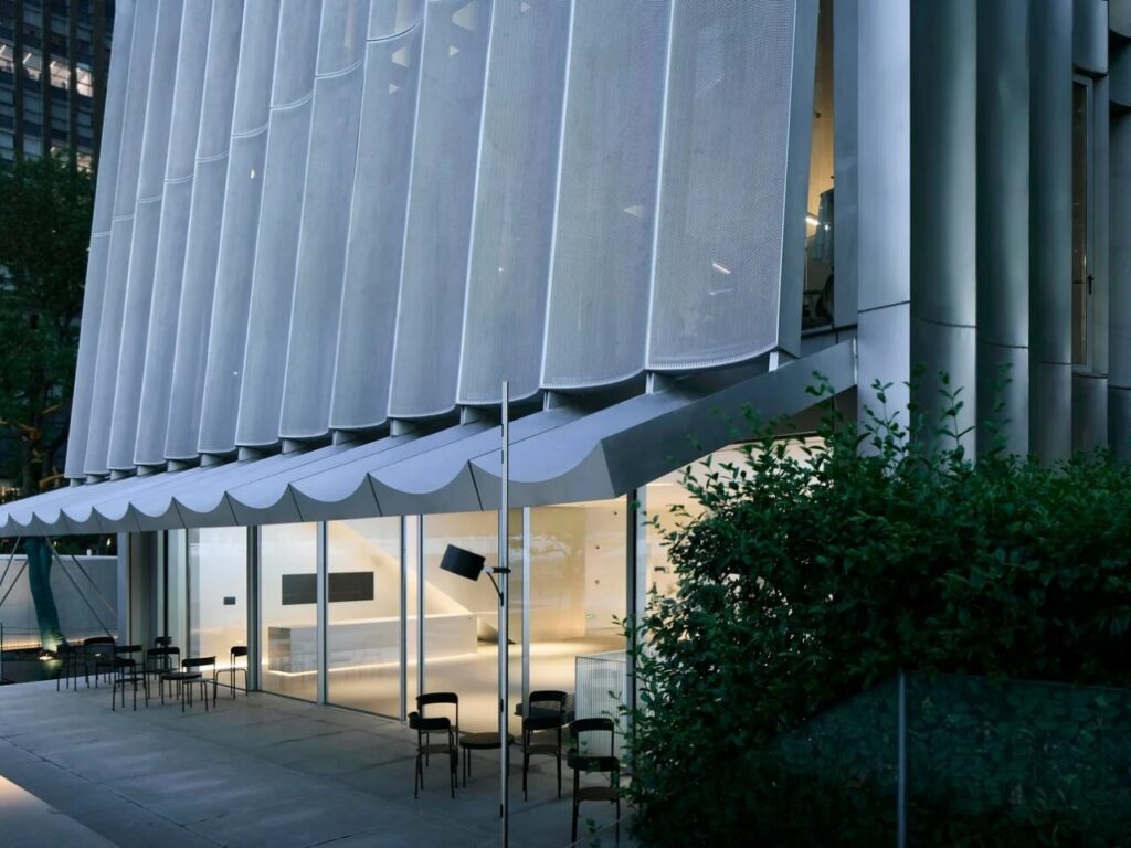 Close-up of the undulating metal mesh facade and glass entrance of the Hangzhou Empathy Museum.