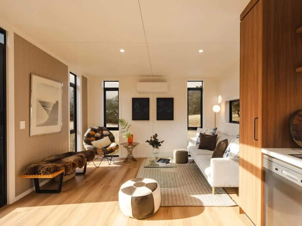 Wide angle shot of the Natural Luxe living area featuring modern seating and integrated storage solutions.