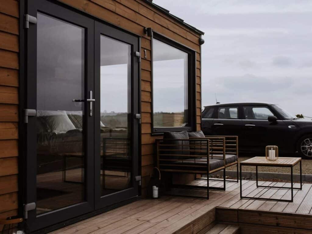 Close-up of the black-framed glass entrance doors and the outdoor seating area of Tiny Amsterdam.