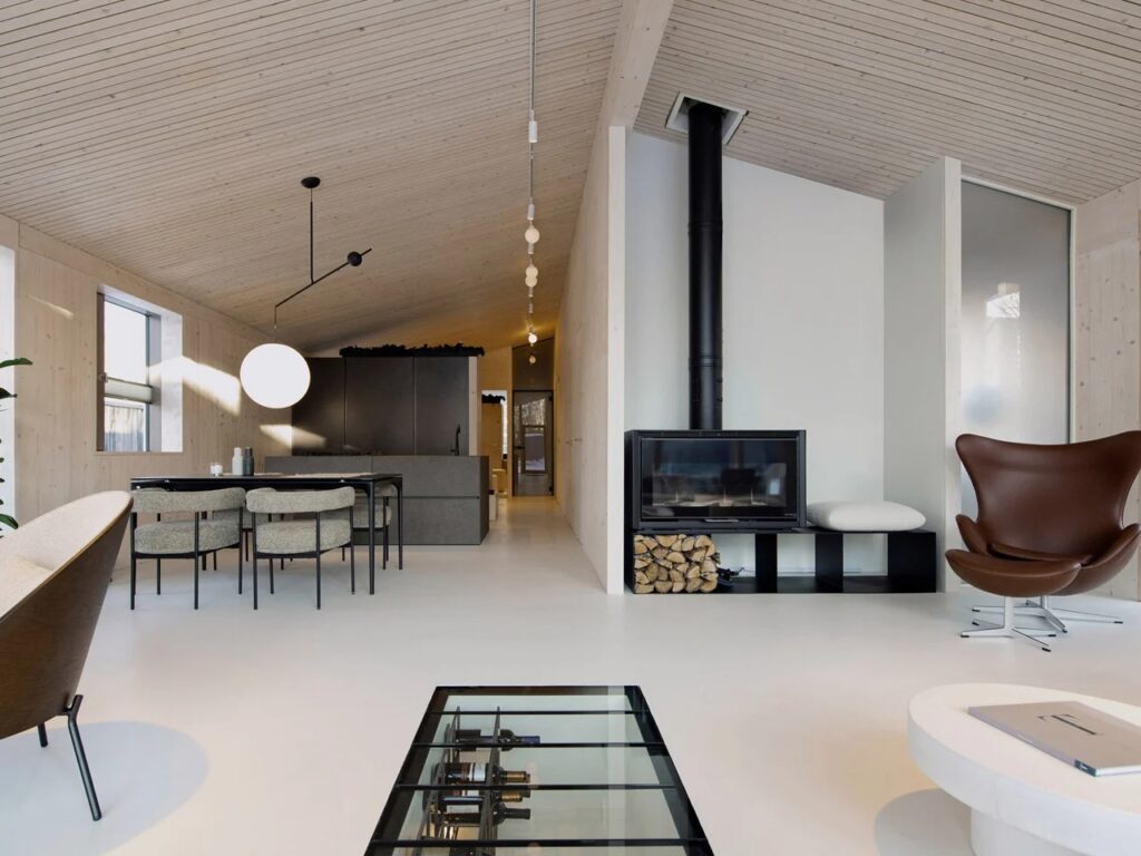 Minimalist interior design with a modern fireplace, wooden ceiling, and designer furniture.