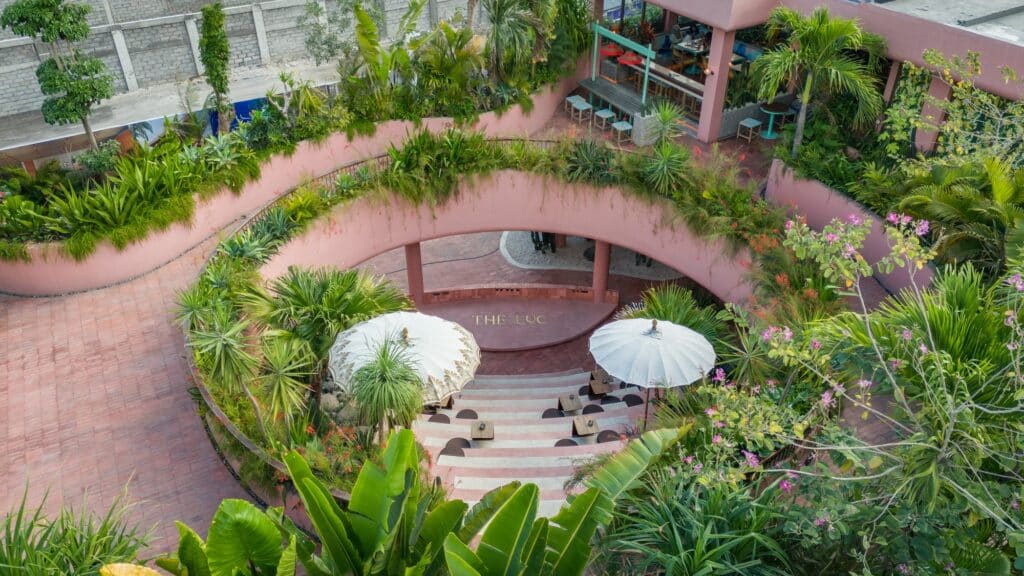 Top-down view of the circular sunken plaza at The LUC Lifestyle surrounded by dense tropical landscaping.
