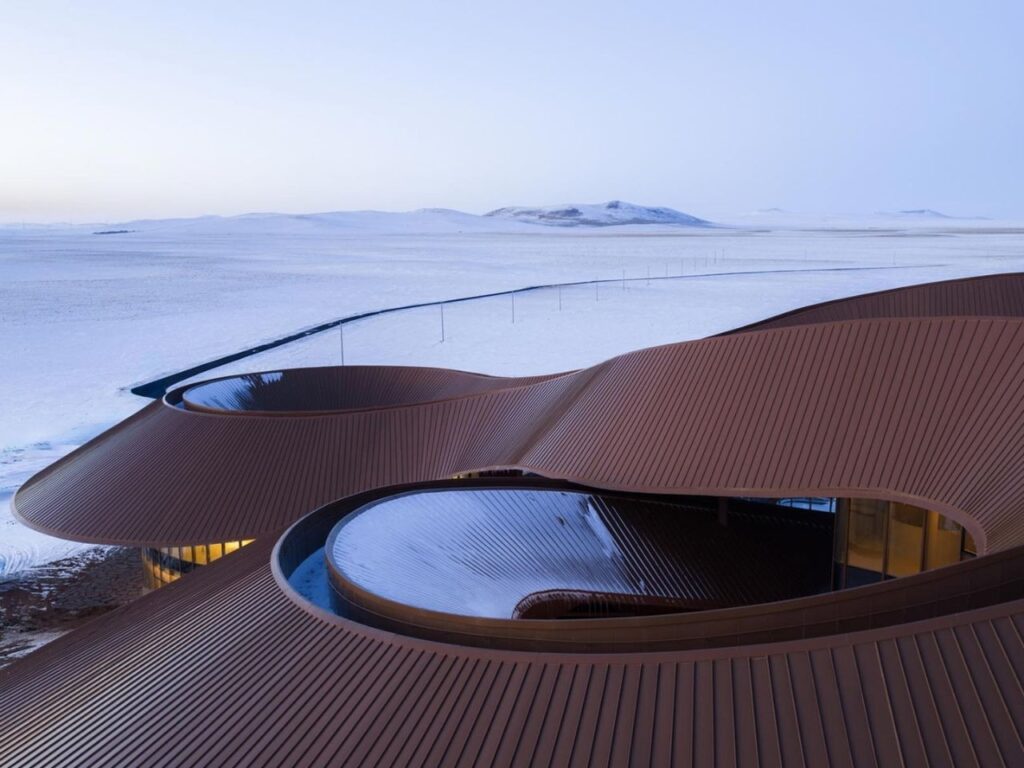 Wide view from the roof of the visitor center looking out over the snowy Xilingol plains and distant volcanoes.