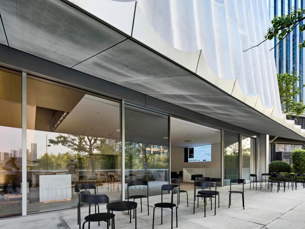 Exterior seating area under the wave-like canopy of the Hangzhou Empathy Museum.