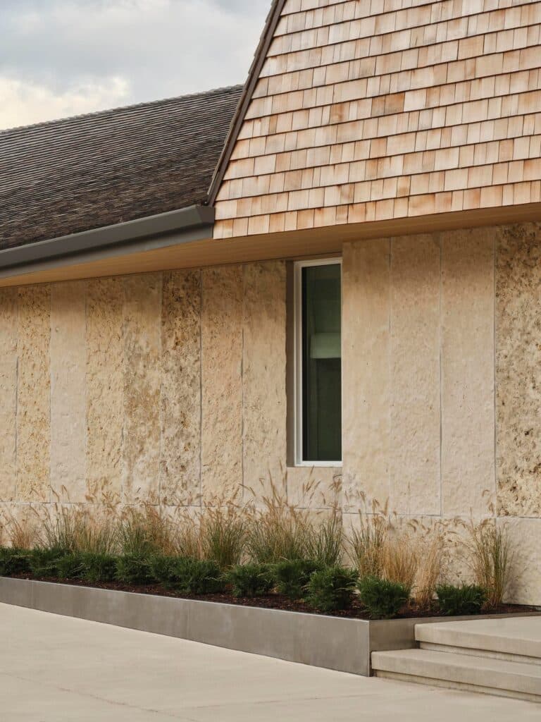 Close-up of local limestone wall cladding and native ornamental grasses at the base of the Georgian Bay residence.