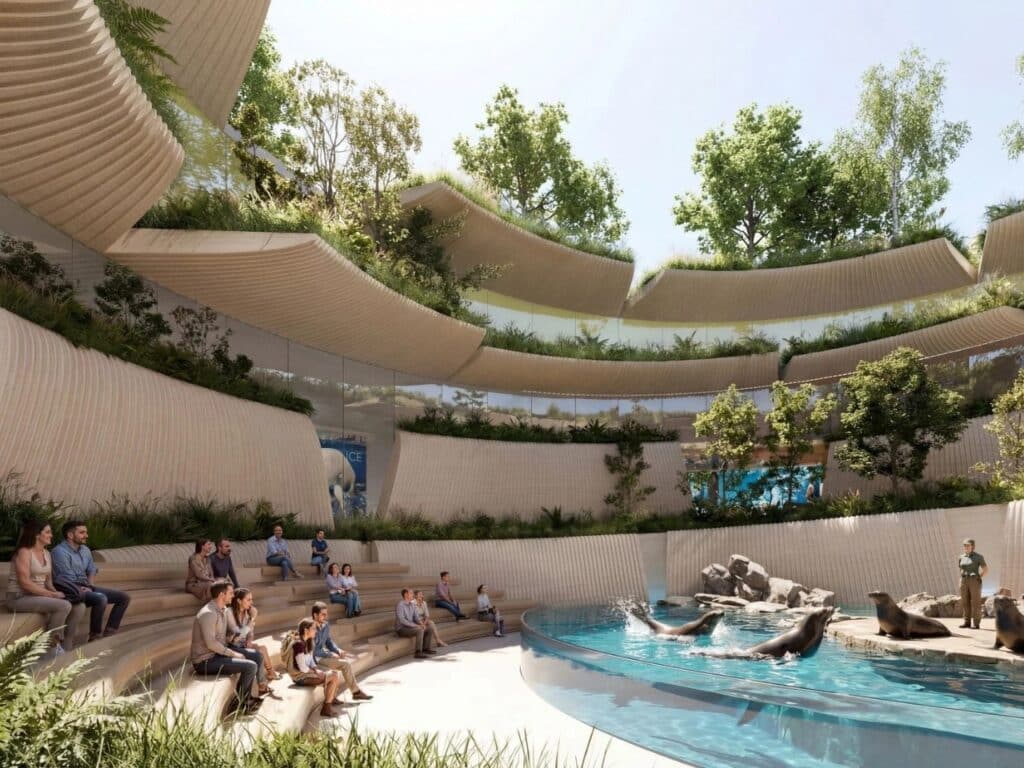 Outdoor amphitheater and sea lion pool at House of Elements with tiered wooden seating and biophilic curved walls.
