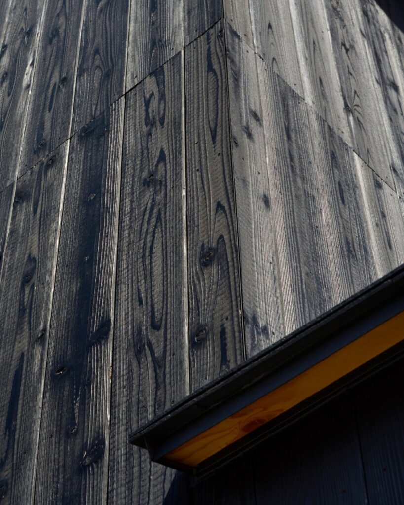 Macro view of charred Yakisugi timber grain on the exterior walls of Onomichi House by Studio Bark.