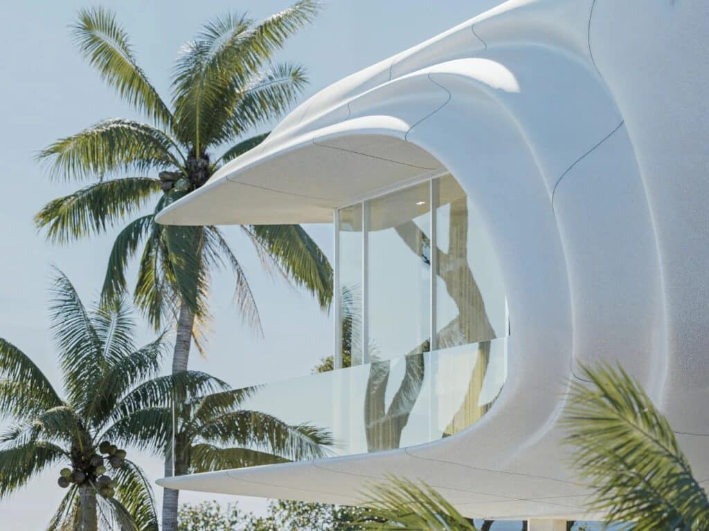 Architectural detail of PERLA's white textured exterior shell against a bright blue sky and palm trees.