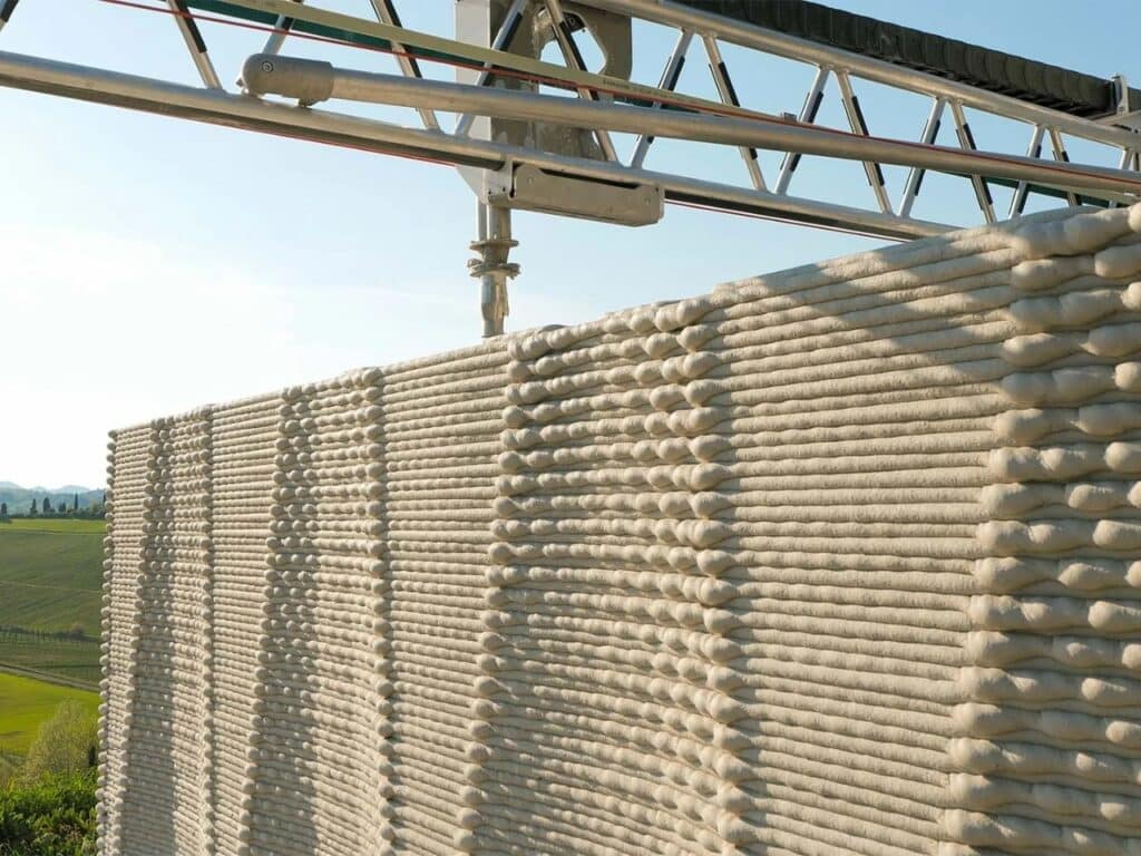Close-up of the layered texture of a 3D-printed wall, showing the rhythmic patterns created by the robotic arm.