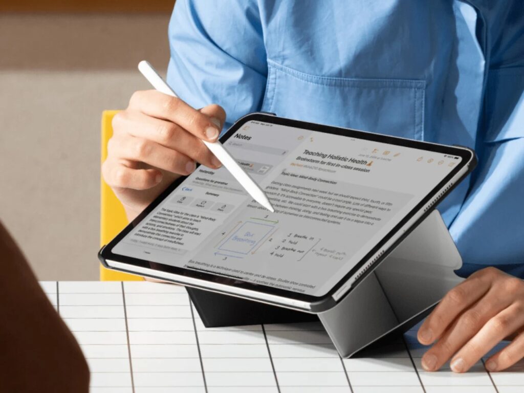 A user writing on an iPad with an Apple Pencil at a low angle, with the folio case providing a stable wedge support.
