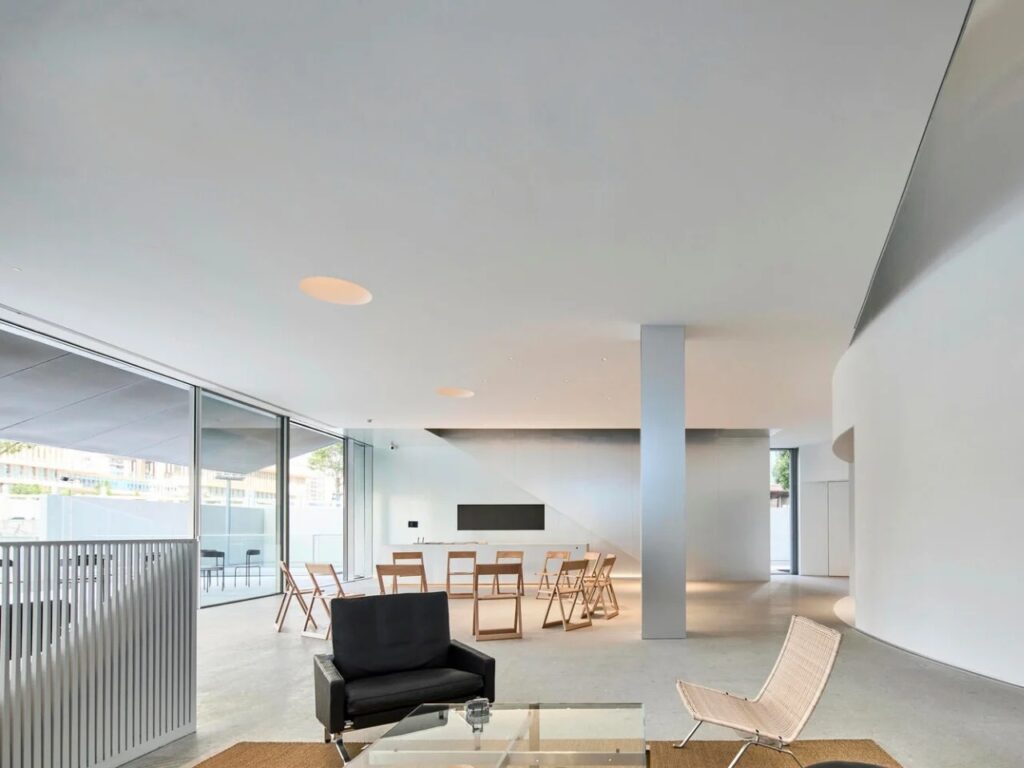 Minimalist interior reception area of the museum with modern furniture and natural light from circular skylights.