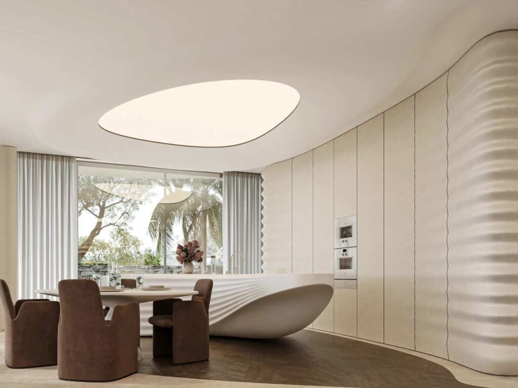 Minimalist kitchen and dining area in PERLA villa with a wave-patterned kitchen island and warm, soft lighting.