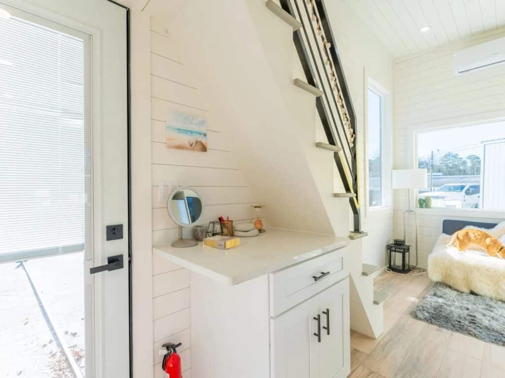 Dedicated home office workspace built into the Sora 20 tiny home under the stairs.