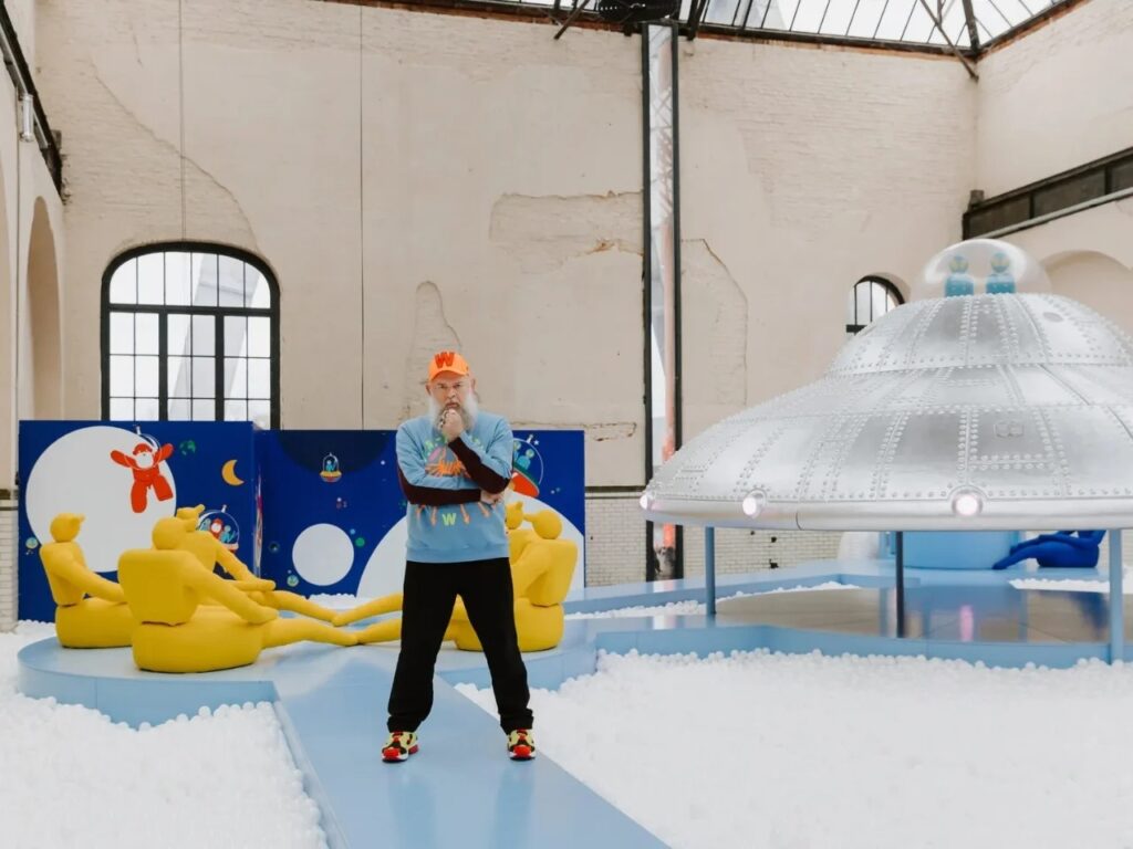 Designer Walter Van Beirendonck standing in front of his "Little Stranger" installation at the industrial site.