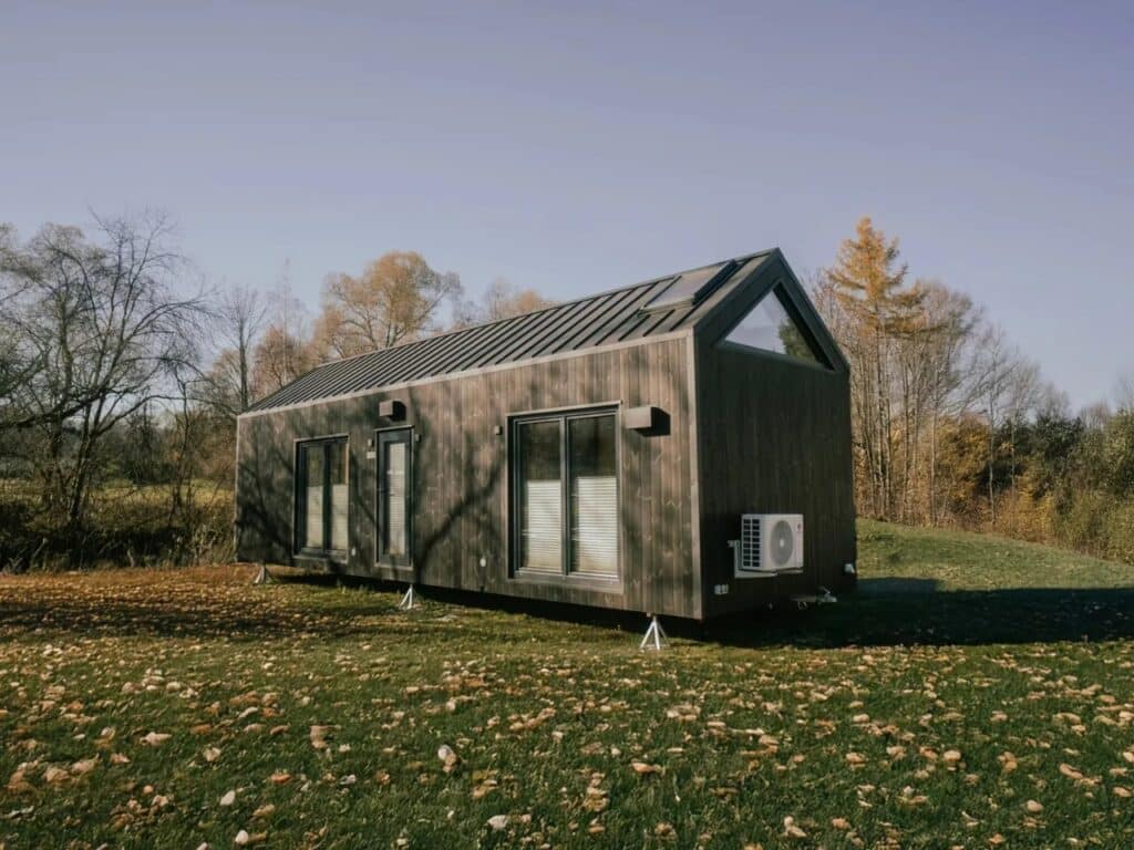 Wide angle of the Zenith tiny house in a rural landscape, emphasizing its off-grid potential and sustainable profile.