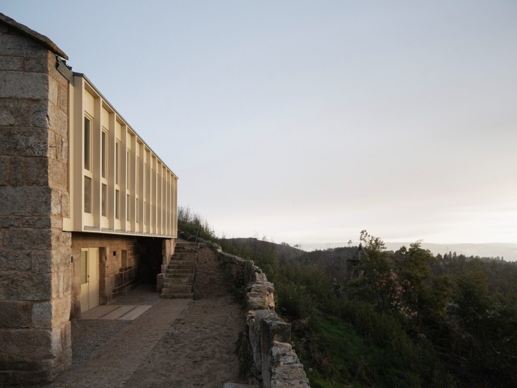 Perspective view of the rehabilitated building&rsquo;s upper level with a modern vertical timber-framed facade overlooking the valley.