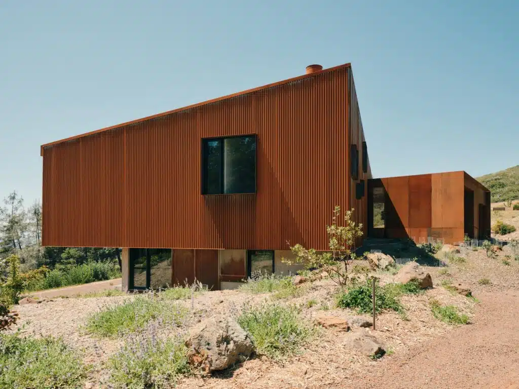 Side view of the corrugated steel facade with minimal window openings for fire protection.