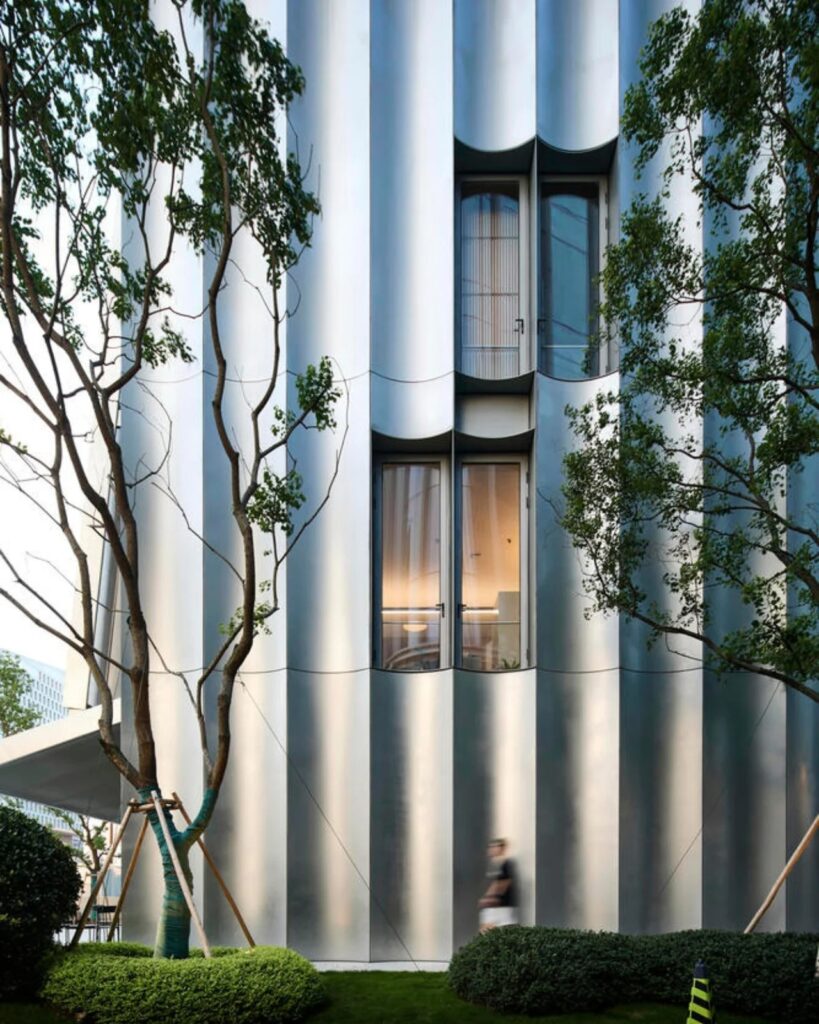 Close-up detail of the undulating stainless steel and aluminum panels on the museum's exterior.