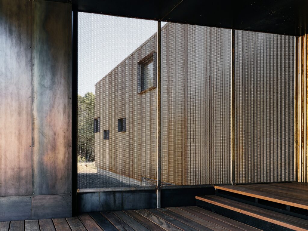View through a perforated metal spark screen from an interior deck looking out.