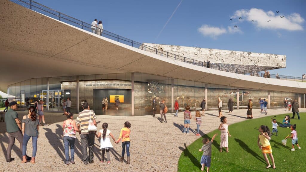 An architectural rendering showing a modern museum building with a sweeping, curved concrete roof and a glass-walled entrance. Diverse groups of people, including families and children, are walking along a gravel plaza and a grassy lawn in front of the museum.
