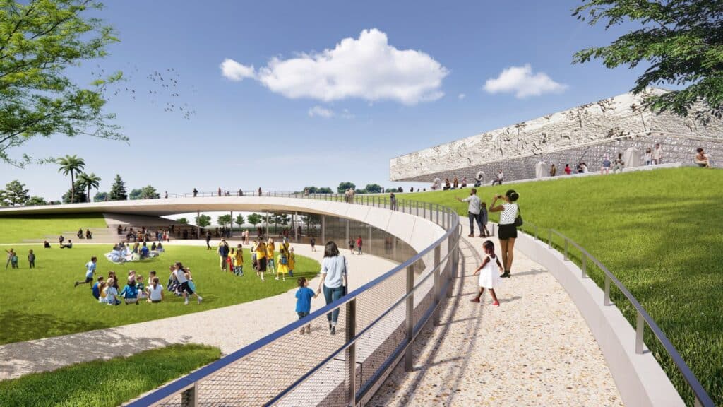 An architectural rendering of a modern, curved walkway and lush green park at the La Brea Tar Pits, featuring people walking and relaxing near a large building with a detailed fossil-relief facade under a bright blue sky.