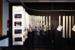 Hanging panels displaying carbon data and sustainability research at Carbon Confessions exhibition