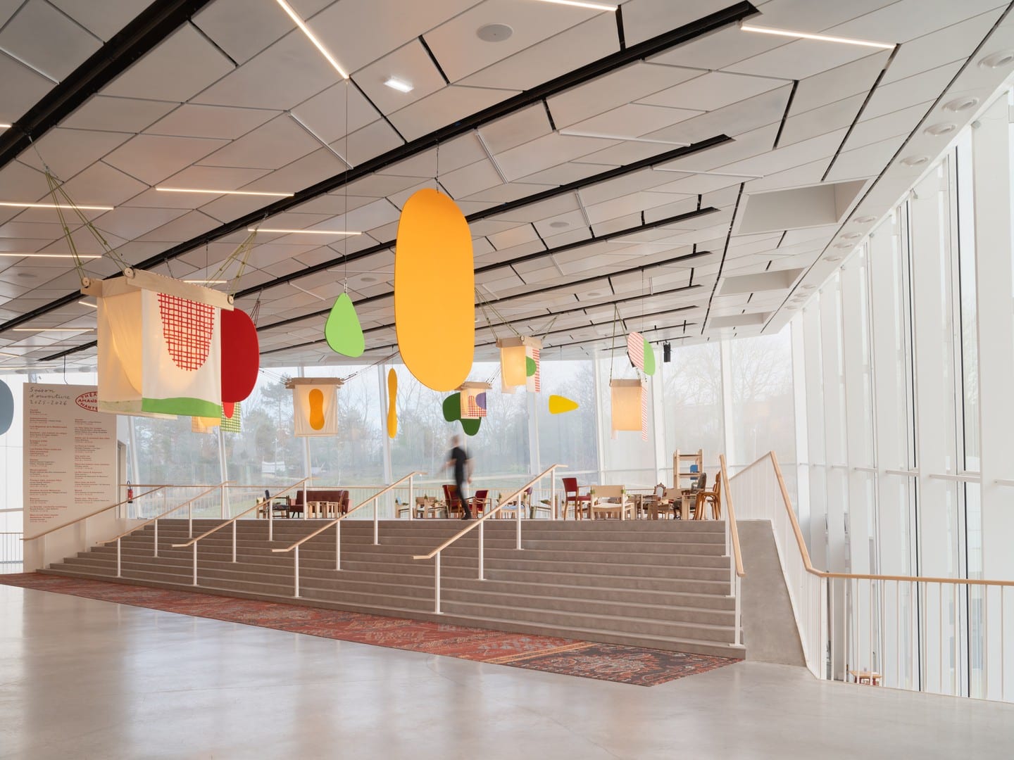 Wide view of the Grand Hall stairs after the theatre redevelopment with colorful hanging acoustic panels.