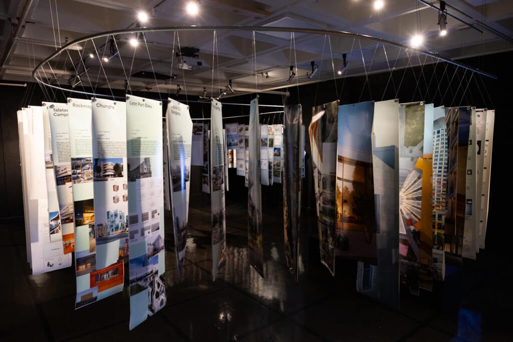 Carbon Confessions exhibition showing project case studies suspended from circular rail at UVA gallery