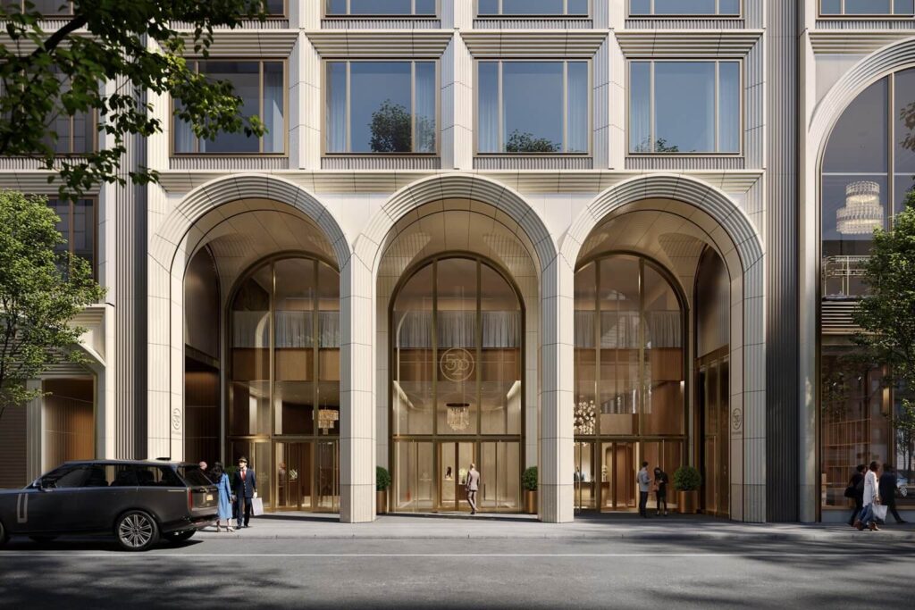 Street-level entrance of 520 Fifth Avenue featuring grand triple-height arches clad in terra-cotta, part of the building's parametric facade system.