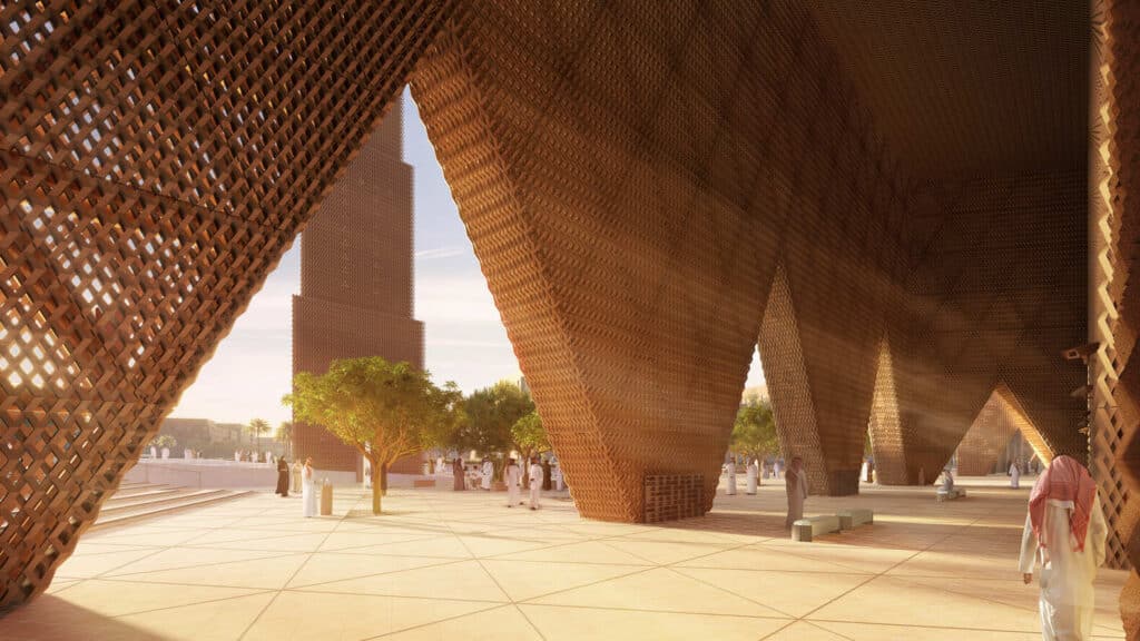 Shaded outdoor plaza with massive geometric pillars and planted trees in Diriyah.
