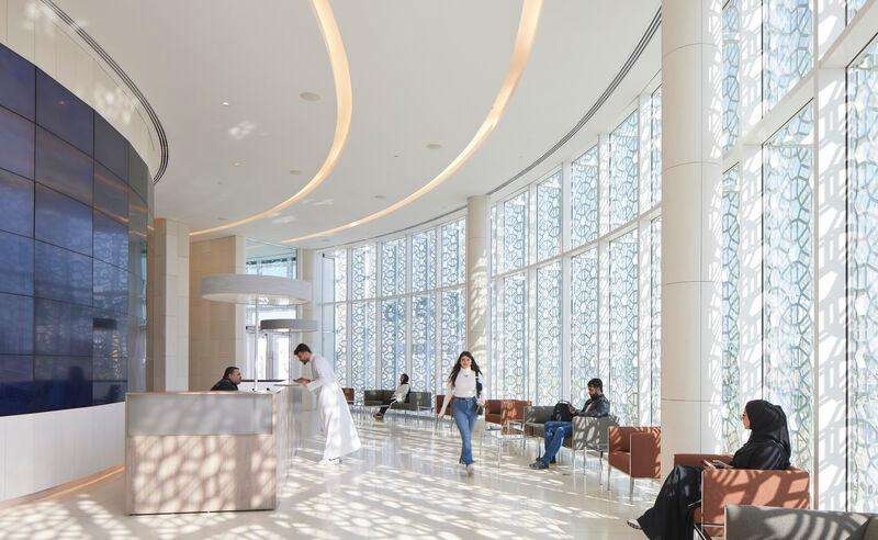 ضوء الشمس المرقط يضيء منطقة الاستقبال الداخلية في حرم جامعة الكويت عبر النوافذ المزخرفة.