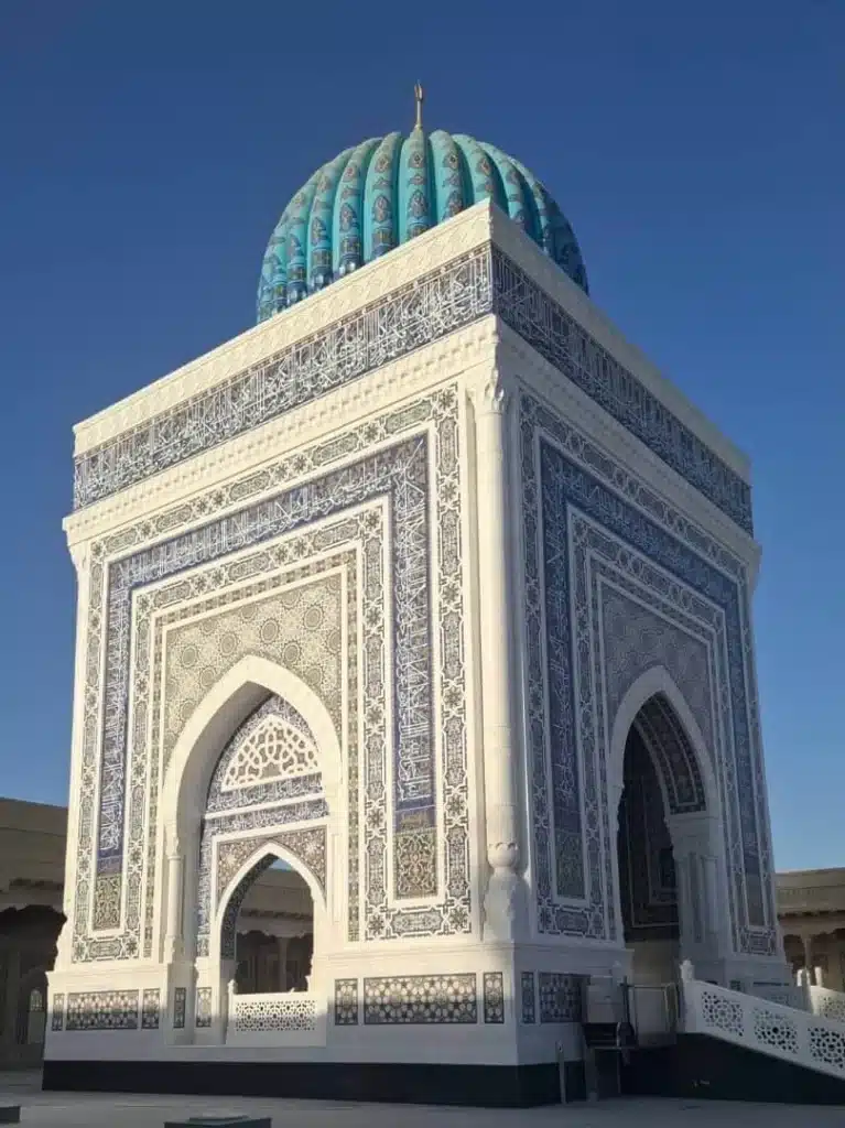 لقطة قريبة لهيكل الضريح تُظهر تفاصيل البلاط الإسلامي والقبة الفيروزية في مجمع البخاري التذكاري