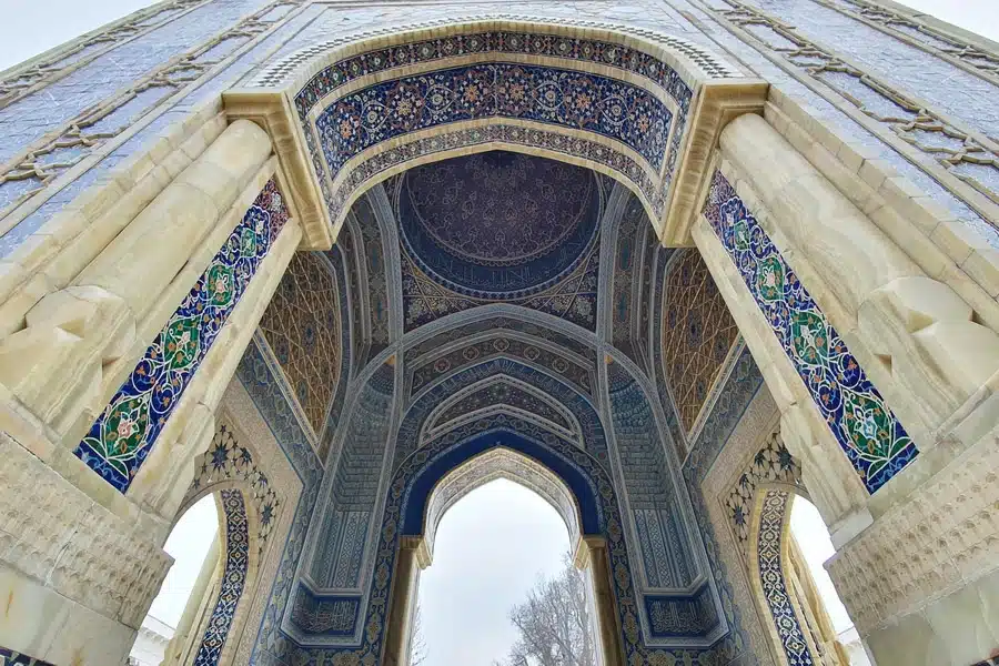 منظر من أسفل لقوس مدخل الضريح يكشف أنماط الفسيفساء الإسلامية الداخلية الدقيقة وزخارف الجص