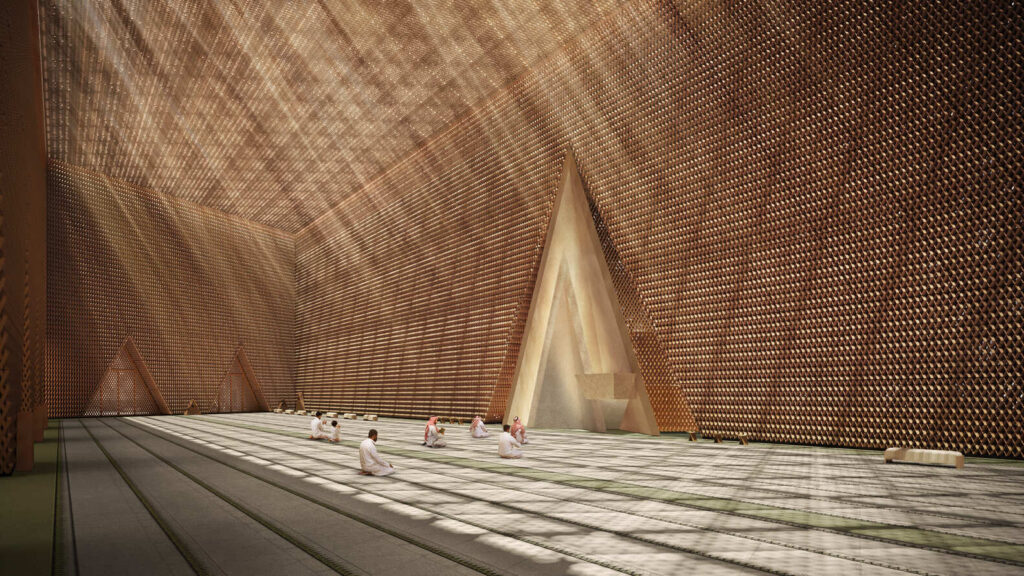 Interior view of the Grand Mosque main prayer hall with natural light filtering through textured walls.
