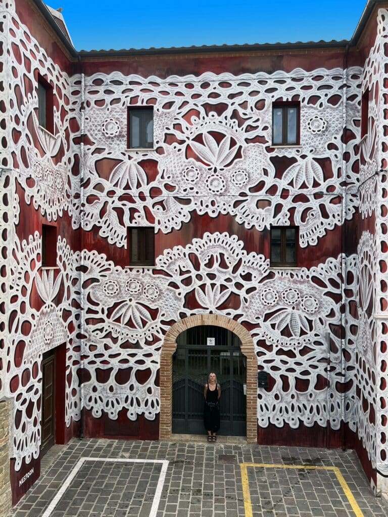 NeSpoon lace pattern mural in Bisenti Italy transforming traditional handmade lace geometry into architectural scale street art.