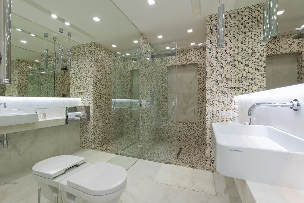 Spacious bathroom with elegant mosaic tiles and frameless glass shower door