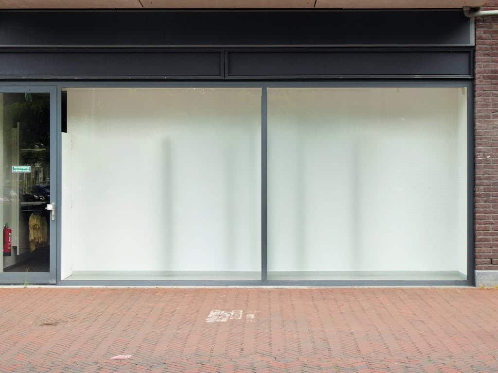 Clean modern storefront with large glass windows, perfect for retail display.