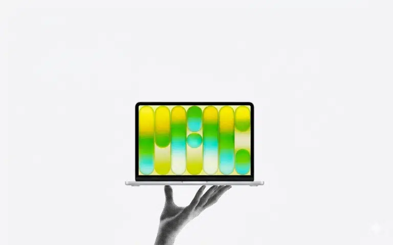 A stylized black-and-white halftone hand holding a modern laptop, which displays a vibrant abstract graphic of yellow, green, and blue gradient pill shapes against a white background.