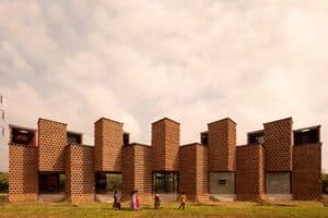 Wide exterior view of Petti Restaurant in Tuticorin featuring vertical shipping containers covered with perforated mud insulation.