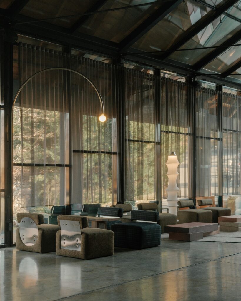 Contemporary lounge area with modular seating and metallic details on chairs reflecting the interior light.